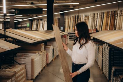 Young woman choosing laminate floor for home renovation. interior designer examining